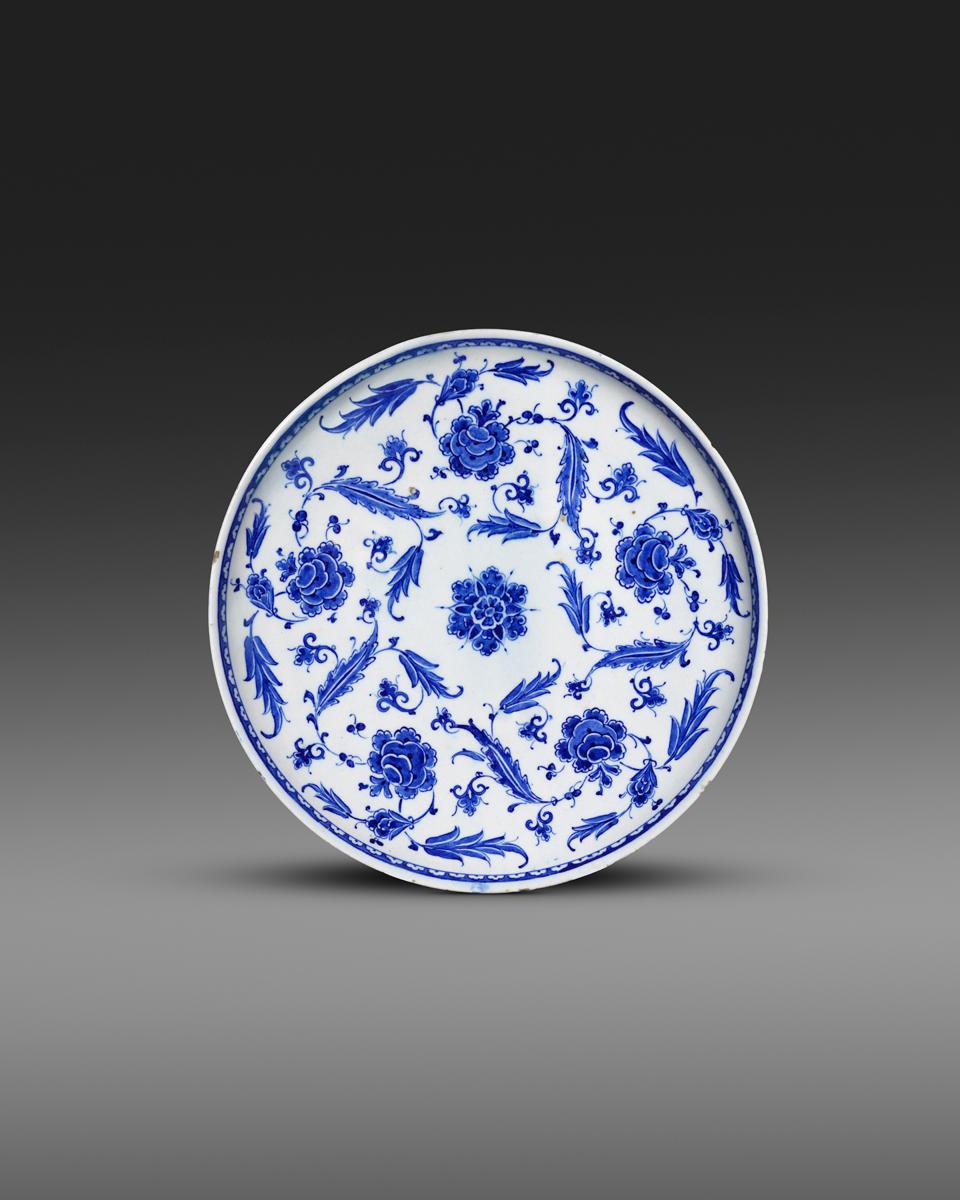 A dish with peonies and serrated leaves 